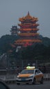 Yellow Crane Tower and a taxi on the Yangtze River bridge in Wuhan at nightfall.