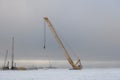 Yellow crane in winter tundra. Dam building, crane, barge, dredger. Works in Siberian tundra