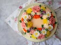 Yellow cream cake decorated with buttercream flowers - peonies, roses, chrysanthemums, carnations - on white wooden background. Royalty Free Stock Photo