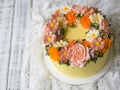 Yellow cream cake decorated with buttercream flowers - peonies, roses, chrysanthemums, scabiosa, carnations - on white wooden back Royalty Free Stock Photo