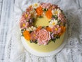 Yellow cream cake decorated with buttercream flowers - peonies, roses, chrysanthemums, scabiosa, carnations - on white wooden back Royalty Free Stock Photo
