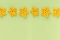 Yellow crocheted flowers row pattern on a green background Royalty Free Stock Photo