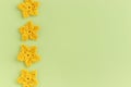 Yellow crocheted flowers row pattern on a green background Royalty Free Stock Photo