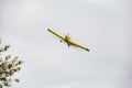 A yellow crop duster in the sky