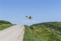 Yellow Crop Duster Spraying Pestisides On Crops Royalty Free Stock Photo