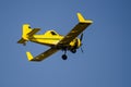 Yellow Crop Dusting Plane Flying in a Blue Sky