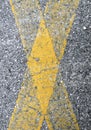 Yellow cross on asphalt