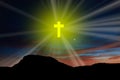 A yellow cross in the sky with rays on the mountain