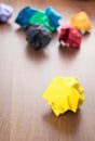 Yellow crumpled paper ball on dark brown wood table with group o Royalty Free Stock Photo