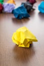 Yellow crumpled paper ball on dark brown wood table with group o Royalty Free Stock Photo