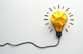 Yellow crumpled paper forms light bulb shape with rays on white background. Abstract concept for new idea or innovation. Simple Royalty Free Stock Photo