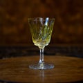 Yellow crystal antique engraved shot glass close-up.