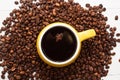 Yellow cup of coffee on coffee beans background. Concept of coffee drink time. Royalty Free Stock Photo