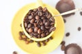 Yellow cup full of natural coffee beans, top view, on a white background. Selective focus. Morning coffee. Royalty Free Stock Photo