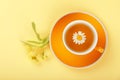 Yellow cup of herbal tea with camomile Royalty Free Stock Photo