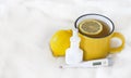 yellow cup of tea with lemon next to nasal spray Royalty Free Stock Photo