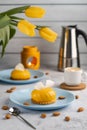 Yellow cupcakes and cup of coffee with yellow tulips on concrete background. Tasty morning dessert Royalty Free Stock Photo