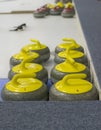 Yellow curling stones on ice