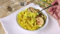 Yellow curry rice and baked zucchini. Hand holds fork with friable rice. Healthy food, cooking spicy vegetables for dinner. Close-