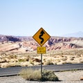 Yellow curve road sign on the road surrounded by rocky mountains  in the Valley of Fire, Nevada Royalty Free Stock Photo