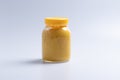 Yellow custard in glass bottle on a white background