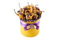 Yellow cylindrical box filled with dried fruits on a white background