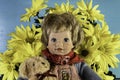 Yellow daisies and teddy bear with small doll