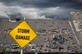 yellow damage warning sign in front of storm damaged roof of house