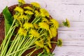 Yellow dandelion flowers in wicker basket on white wooden background. Top view Royalty Free Stock Photo