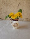 Beautiful yellow dandelions in a vase on the table, spring flowers, clear weather.