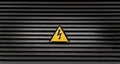 Yellow danger sign on a black striped wall Royalty Free Stock Photo