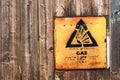 Yellow danger sign on wooden fence