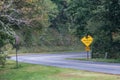 Yellow Dangerous Curve Sign Along a Mountain Roadway Royalty Free Stock Photo