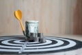 Yellow dart arrow hit the center target of dartboard and money c Royalty Free Stock Photo