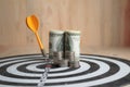 Yellow dart arrow hit the center target of dartboard and money c Royalty Free Stock Photo