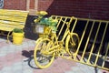 A yellow decorative bicycle with flowers stands in the parking lot on a summer day. Royalty Free Stock Photo