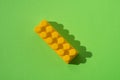 Yellow detail of children`s constructor isolated on green background