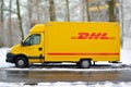 Yellow DHL international courier and parcel deliivery service truck in snow