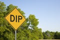Yellow Dip Sign Against Blue Sky And Green Trees Royalty Free Stock Photo