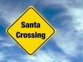 Yellow diamond shaped road warning sign with a Christmas theme concept. Santa Crossing text. Royalty Free Stock Photo