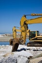 Yellow diggers on the seashore Royalty Free Stock Photo