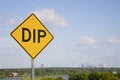 Yellow Dip Sign Against Blue Sky With City Skyline Royalty Free Stock Photo