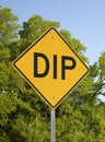 Yellow Dip Sign Against Blue Sky And Green Trees Royalty Free Stock Photo