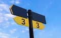 Yellow direction sign on the pole against the blue sky. Yellow arrow signal against sky Royalty Free Stock Photo