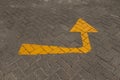 A yellow directional arrow painted on a paved road Royalty Free Stock Photo