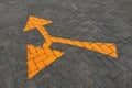 A yellow directional arrow painted on a paved road Royalty Free Stock Photo