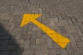 A yellow directional arrow painted on a paved road Royalty Free Stock Photo