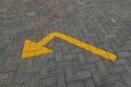 A yellow directional arrow painted on a paved road Royalty Free Stock Photo