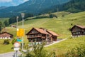 Yellow directional road signs. Wooden house in the background.