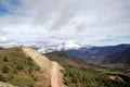 A yellow dirt road leads to the top of the mountain